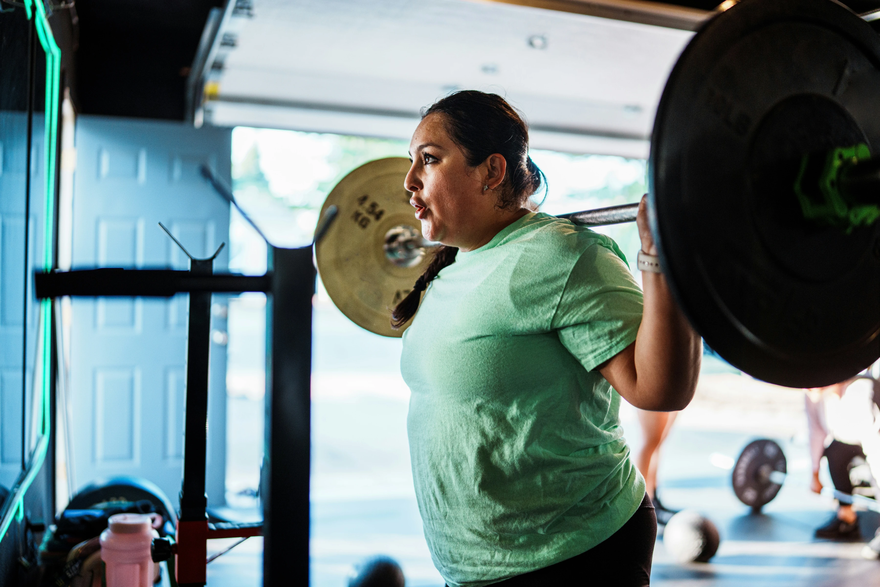 A woman lifting a barbell in a focused strength session